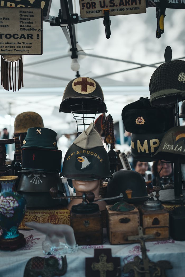 Collection of vintage military helmets showcased at an outdoor market stall with historical memorabilia.